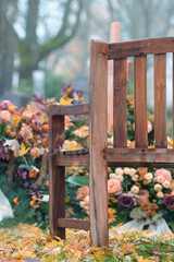 Fototapeta na wymiar Holzbank am Grab stehend, Blumen, kein Text Keine Menschen