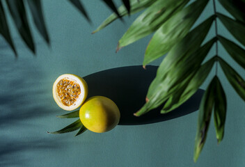 Yellow Maracuja or Golden Passionfruit at green background, top view through the tropical leaves of palm. Horizontal composition with exotic fruit from Brazil.
