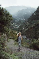 Adventurous girl is hiking a path up the hill