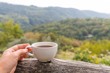 Cup of coffee in the hand on the terrace