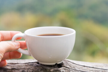 Cup of coffee in the hand on the terrace