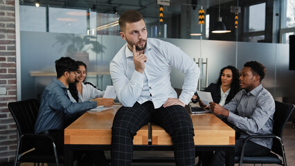 Thoughtful pensive man leader boss businessman company CEO sitting on office table thinks about...