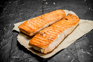 Grilled salmon fillet on paper .