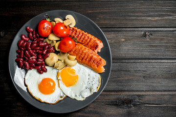 Traditional English Breakfast with fried eggs, sausages and beans.