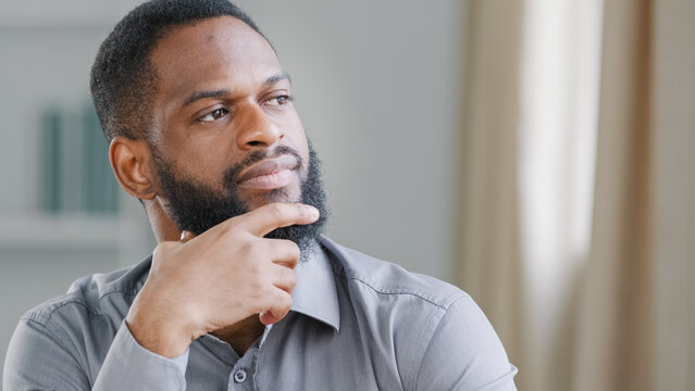 Close up thoughtful pensive ethnic bearded African American man thinking businessman worker searching solution boss think ponder idea business strategy dreaming pondering in office deep in thoughts