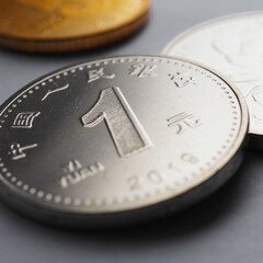 Translation: People's Bank of China, one yuan. PRC money lies on gray surface. 1 yuan coin close-up. Economy and finance. Central bank and business. Chinese yuan renminbi. Square illustration. Macro