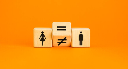 Symbol for gender equality. Turned a cube and changed a unequal sign to a equal sign between symbols of men and women. Beautiful orange table orange background, copy space. Gender equality concept.