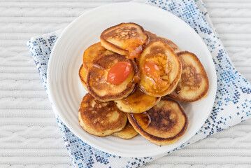 On a white plate are freshly prepared pancakes with apricot jam.