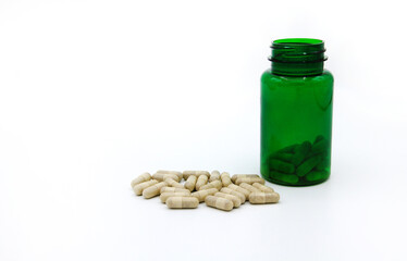 White pills or capsule with green pill bottle isolated on white background with copy space for add text. Healthy, herb, container object and Medicine. Food supplement for cure or repair health