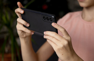 Hands of a girl with a smartphone close-up. Take a selfie on your phone or shoot a video for social networks. Free time on the Internet, instant messengers, smartphone applications