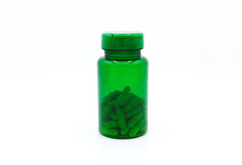 Green plastic bottle of pills or capsules isolated on white background. Healthy food, herbs, container object and Medicin e. Food supplements for cure or repair health.