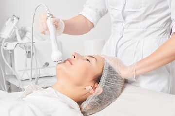 Beautician makes RF lifting for rejuvenation woman face, anti aging cosmetic procedure in beauty...
