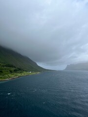 Fjords coastline, ocean bay coastline, cloudy foggy sky