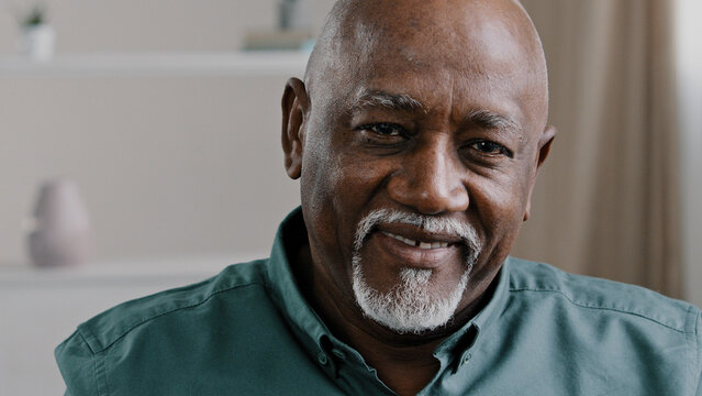 Male Portrait Indoor African Elderly Grandfather At Home Looking At Camera With Friendly Smile. Old Business Worker In Office Company CEO Mature Senior American Man Ethnic Businessman Elder Generation