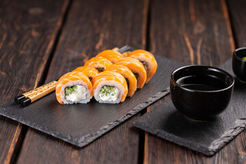 Sushi roll philadelphia with salmon and cucumber and cream cheese on black background. Sushi menu. Japanese food concept
