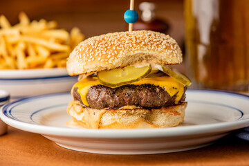 Hamburger. Bacon Cheeseburger. Classic traditional American bar, restaurant entree. Beef hamburger with Swiss and cheddar cheeses served with lettuce, tomato, onion and hand cut french fries. 