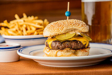 Hamburger. Bacon Cheeseburger. Classic traditional American bar, restaurant entree. Beef hamburger with Swiss and cheddar cheeses served with lettuce, tomato, onion and hand cut french fries. 