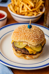Hamburger. Bacon Cheeseburger. Classic traditional American bar, restaurant entree. Beef hamburger with Swiss and cheddar cheeses served with lettuce, tomato, onion and hand cut french fries. 