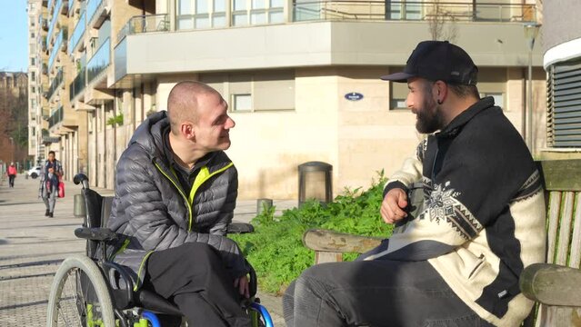 Eugeni 4k 07Disabled person in a wheelchair with a friend sitting having fun and talking