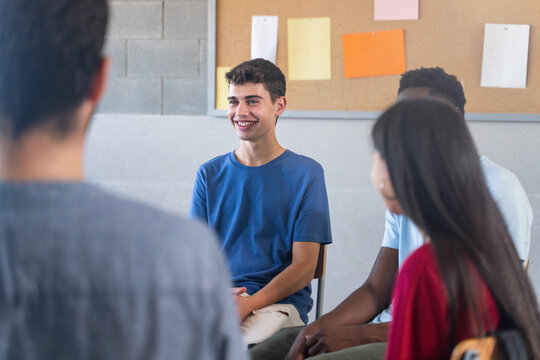 Happy Teenager student talking to classmates - Support Group discussion at School