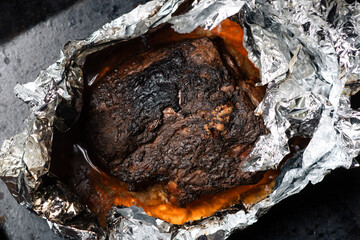 A piece of meat baked in the oven in foil. Home cooking.