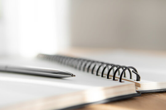 notebook and pen close up with a blurred background in the foreground - Powered by Adobe