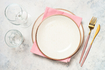 Table setting with white plate and pink cutlery at white background. Top view with copy space.