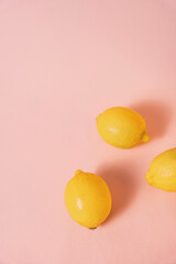 Fruit flat lay with lemons on pink background, with copy space