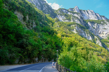 picturesque mountain road in the mountains,  and a pedestrian lane with a boy walking. Genga, Marche, Italy. The Appennines 