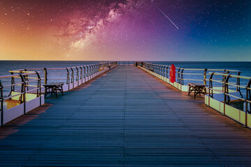 Landscape with Milky way galaxy and Sunset over pier at Saltburn by the Sea, North Yorkshire, UK.