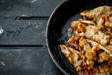 Fried bacon in a frying pan.