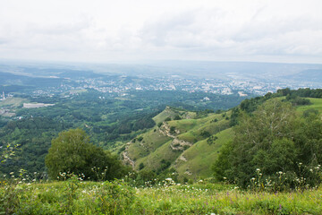 Obraz premium panorama of green hills and valleys in a hazy haze on the horizon in Kislovodsk on a cloudy summer day and space for copying