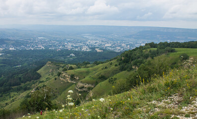 Fototapeta na wymiar panorama of green hills and valleys in a hazy haze on the horizon in Kislovodsk on a cloudy summer day and space for copying