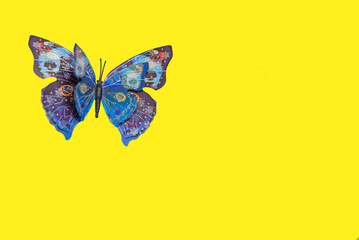 Fototapeta na wymiar Mariposa artesanal en fondo amarillo