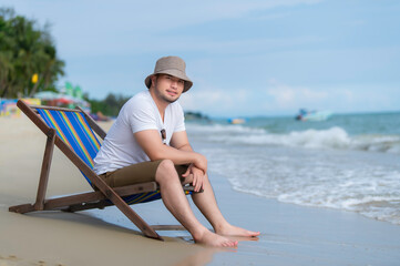 Asian man sitting chair beach inside sea,Relax time at summer