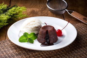 Delicious fresh fondant with hot chocolate and ice cream served on plate. petit gateau