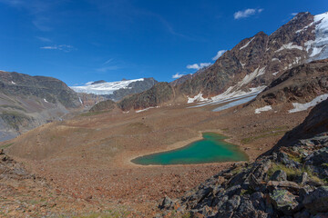 Small turquoise glacial lake among ancient moraines. Gepatschferner and Barba d'Orso glaciers are visible. Vallelunga, Alto Adige Sudtirol, Italy