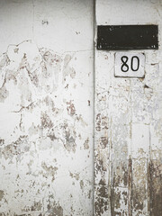 old house address number plates on grungy white wall
