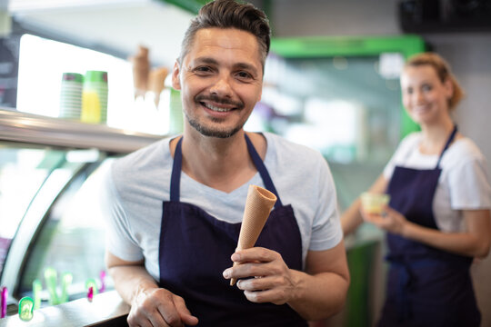 worker working with coworker at counter in ice cream parlor