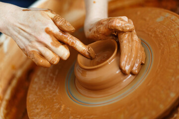Potter creates a pitcher on a pottery wheel