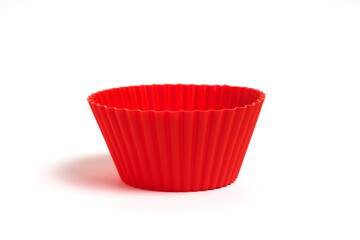 Red silicone mold for baking cupcakes on a white background