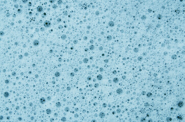 Cosmetic product foamy smudges. Foam texture on a blue background. Skincare, washing the face concept.
Soap, shampoo bubbles close up.
