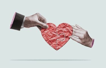 A man and a woman build a heart from a puzzle.