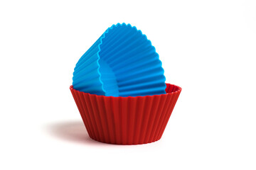 Blue and red silicone molds for baking a cupcake on a white background