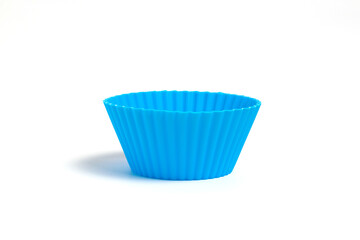 Blue silicone mold for baking a cupcake on a white background