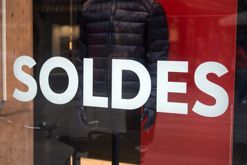 Closeup of discount sign SOLDES in french,  the traduction of  sales in english on the window of...