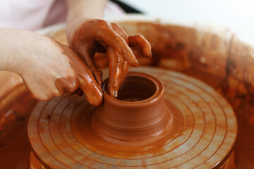 Potter creates a pitcher on a pottery wheel