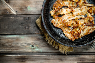 Fried bacon in a pan.