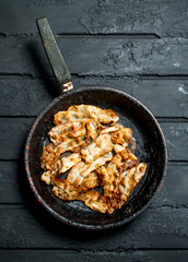 Fried bacon in a frying pan.