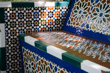 ornate tiled bench in the shade of an orange tree in Seville, Spain